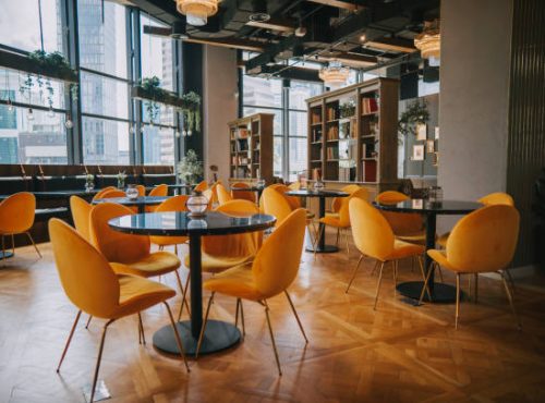 modern Cafe restaurant interior with yellow chair against window with city view